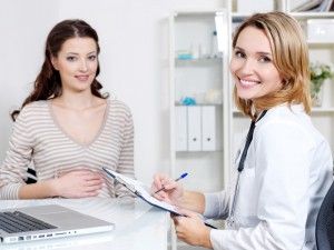 Happy doctor with her patient - young beautiful pregnant woman